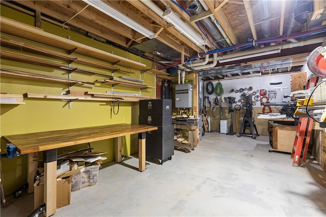 basement with water heater and a workshop area