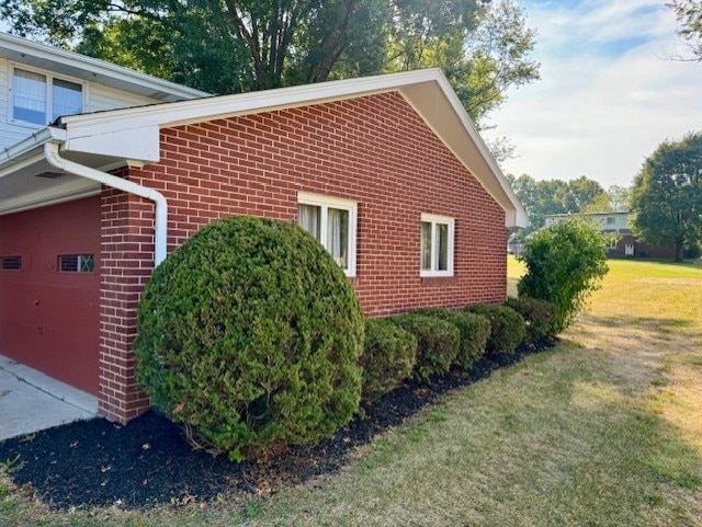 view of property exterior with a garage and a lawn