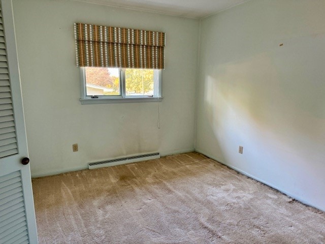 spare room with a baseboard radiator and light colored carpet