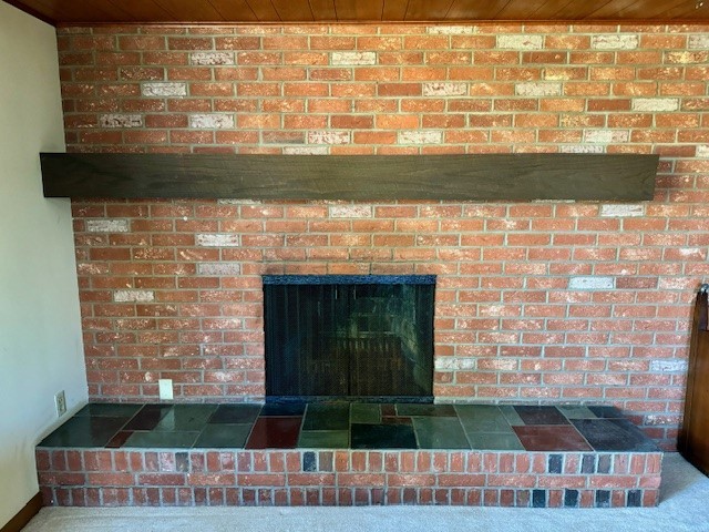 interior details with wood ceiling, carpet floors, and a fireplace