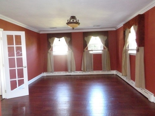 unfurnished room with hardwood / wood-style flooring and crown molding