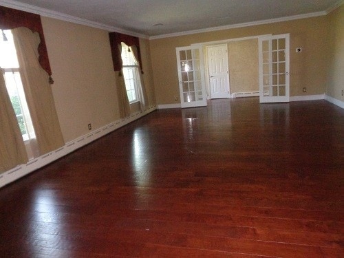 interior space with a healthy amount of sunlight, crown molding, and dark hardwood / wood-style flooring