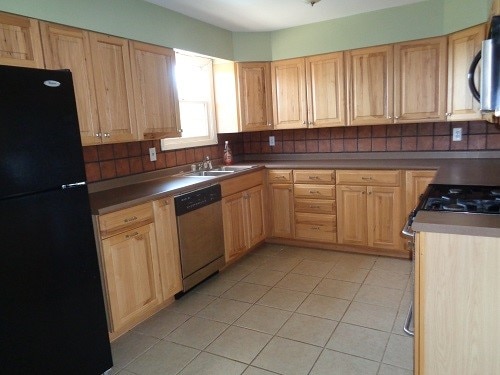 kitchen with light tile patterned floors, appliances with stainless steel finishes, sink, and light brown cabinets