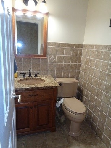 bathroom featuring tile walls, tile patterned flooring, vanity, and toilet