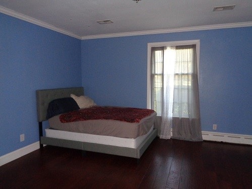 bedroom featuring a baseboard radiator, dark hardwood / wood-style floors, and crown molding