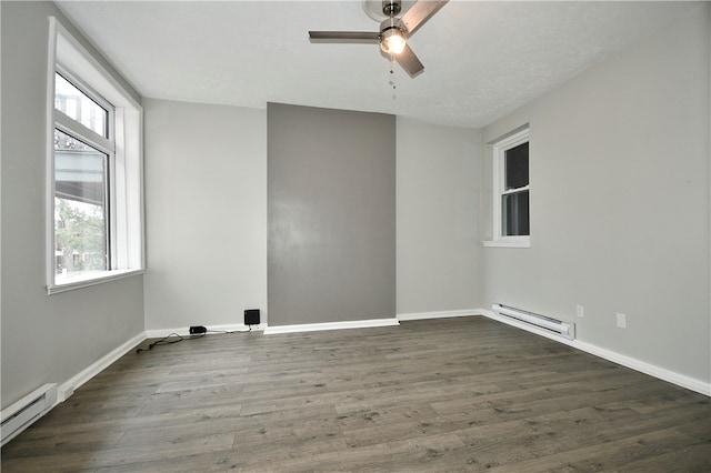 empty room with a baseboard heating unit, a healthy amount of sunlight, ceiling fan, and dark hardwood / wood-style flooring