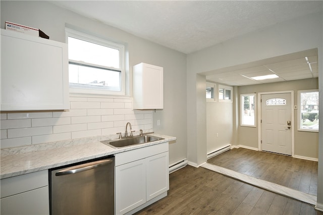 kitchen with a wealth of natural light, stainless steel dishwasher, a baseboard heating unit, and dark hardwood / wood-style flooring