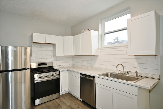 kitchen featuring appliances with stainless steel finishes, white cabinetry, and sink