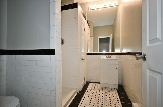 bathroom featuring tile patterned flooring, tile walls, toilet, and tiled shower