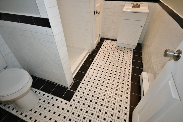 bathroom featuring tile walls, toilet, vanity, and tile patterned flooring