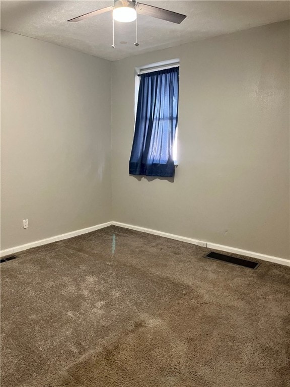 carpeted spare room with a textured ceiling and ceiling fan