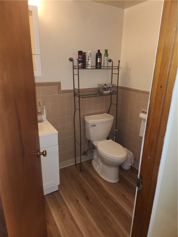 bathroom featuring vanity, tile walls, toilet, and wood-type flooring