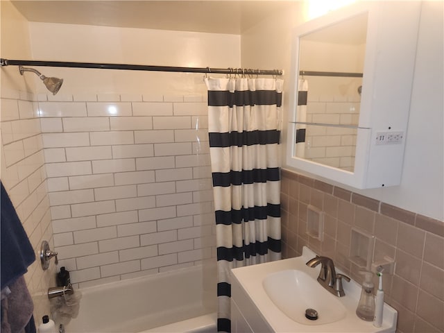 bathroom featuring tile walls, shower / tub combo, and sink