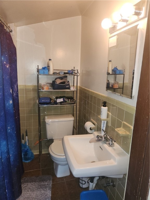 bathroom featuring sink, tile patterned floors, a shower with curtain, tile walls, and toilet