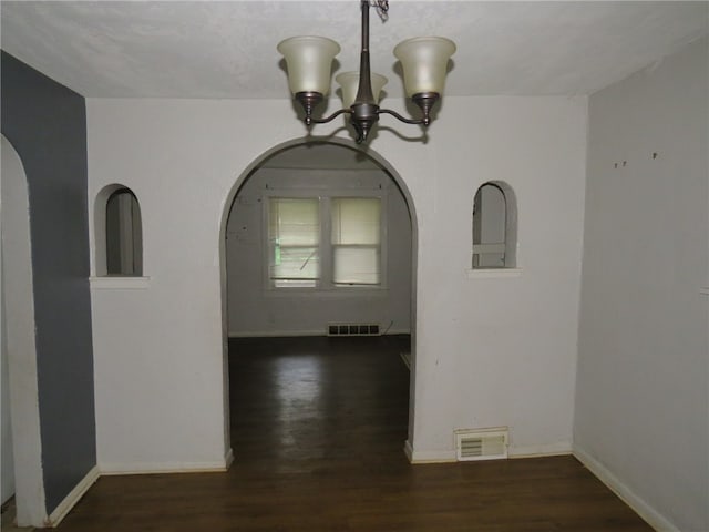 interior space featuring an inviting chandelier and dark wood-type flooring