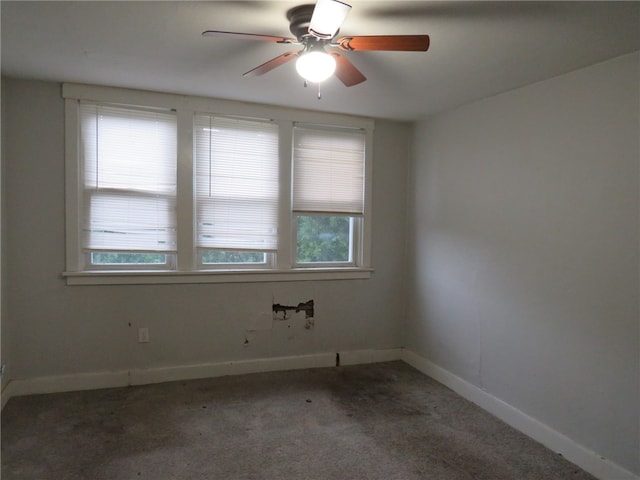 unfurnished room with dark carpet, ceiling fan, and plenty of natural light