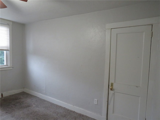 carpeted spare room featuring ceiling fan