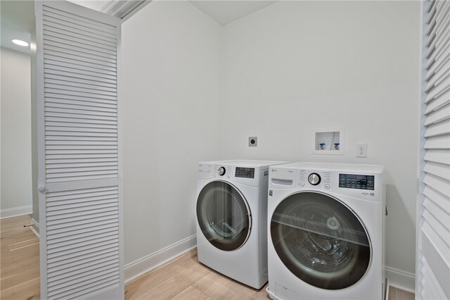 laundry room featuring light wood-type flooring and separate washer and dryer