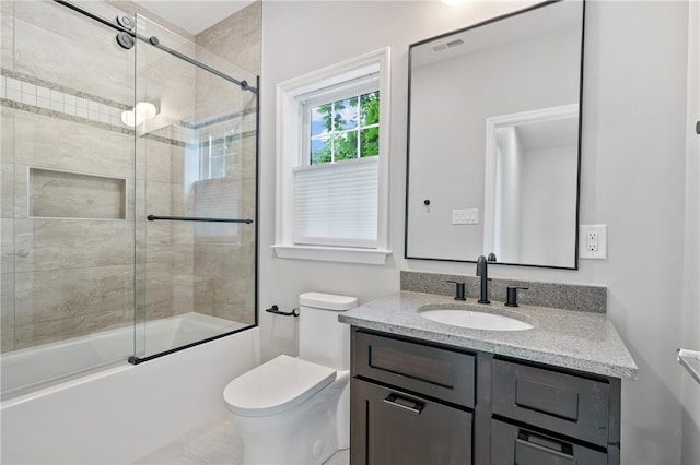 full bathroom featuring shower / bath combination with glass door, vanity, toilet, and tile patterned flooring