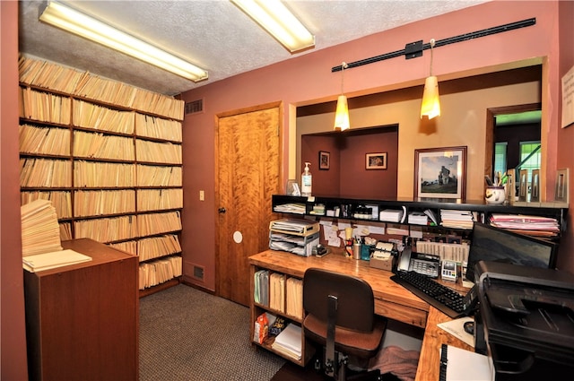 carpeted office with a textured ceiling