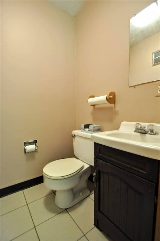 bathroom with tile patterned flooring, toilet, and vanity