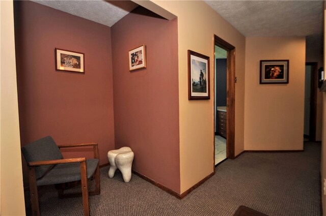 corridor with a textured ceiling and carpet