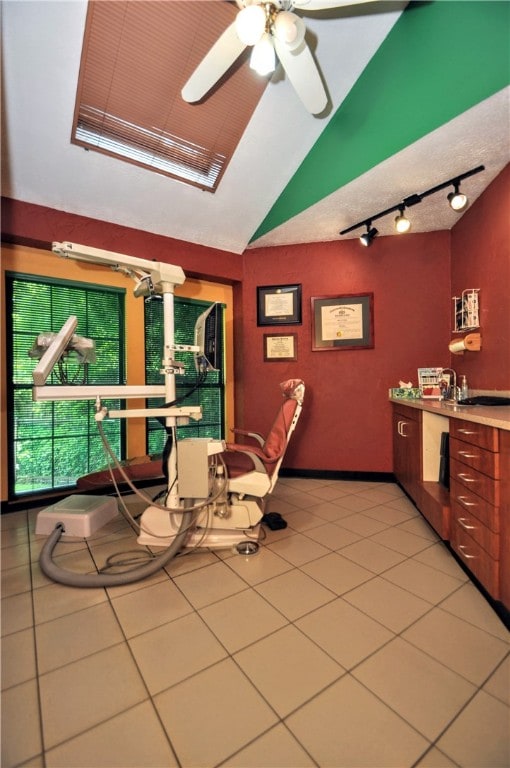 tiled dining room featuring ceiling fan and vaulted ceiling