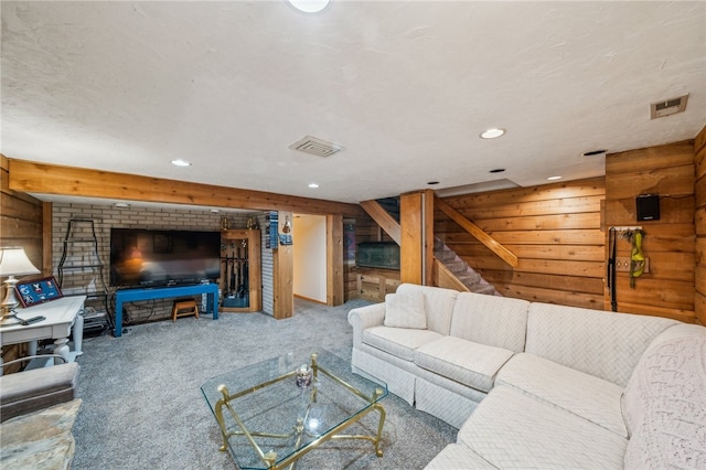 carpeted living room featuring wood walls