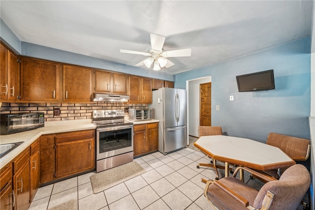 kitchen featuring ceiling fan, light tile patterned floors, stainless steel appliances, and tasteful backsplash