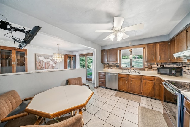 kitchen with ceiling fan with notable chandelier, stainless steel appliances, sink, decorative backsplash, and hanging light fixtures