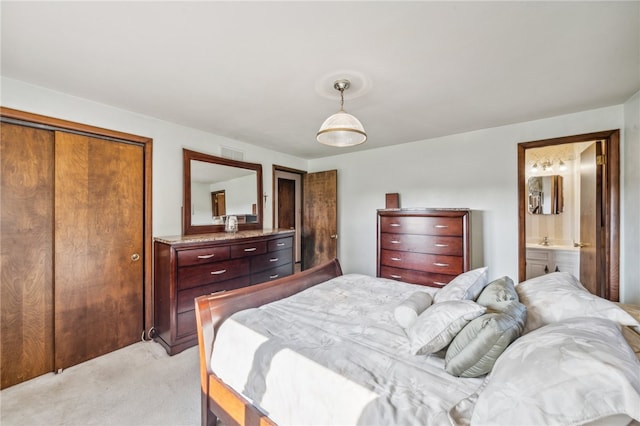 carpeted bedroom with ensuite bathroom and a closet