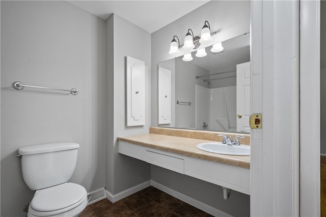 bathroom featuring walk in shower, vanity, toilet, and tile patterned floors