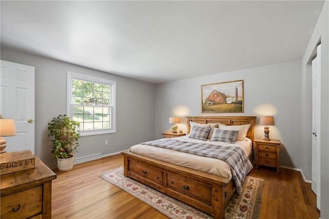 bedroom featuring wood-type flooring and a baseboard radiator