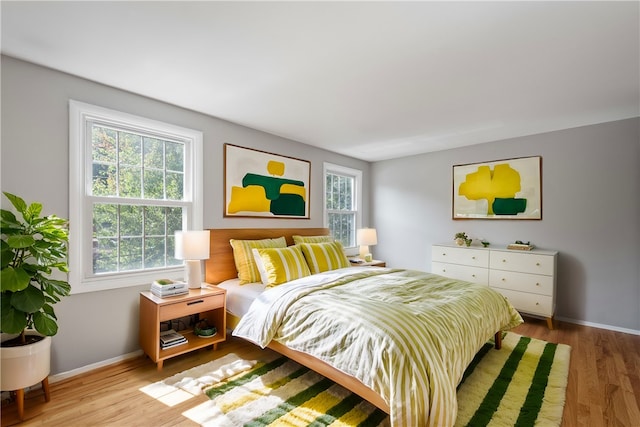 bedroom with light hardwood / wood-style flooring and multiple windows