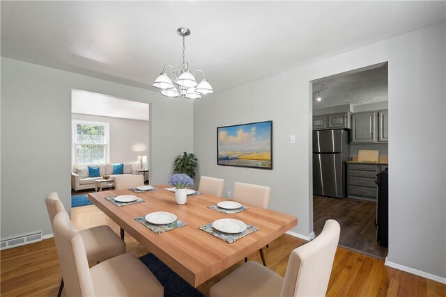 dining area featuring a chandelier and dark wood-type flooring