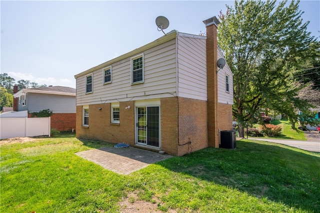 rear view of house with cooling unit and a yard