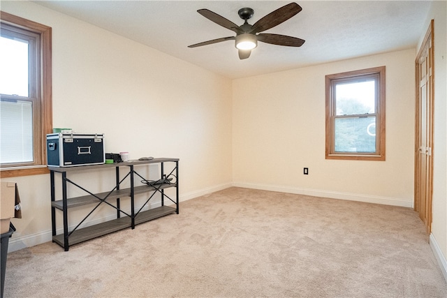 spare room with ceiling fan and light colored carpet