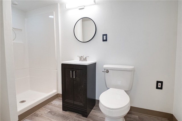 bathroom featuring hardwood / wood-style floors, vanity, a shower, and toilet