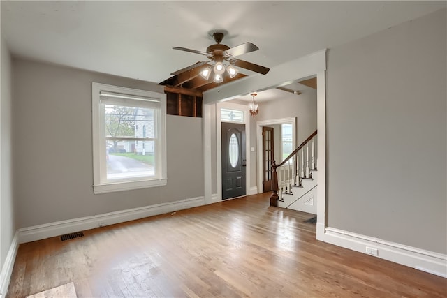 entrance foyer with ceiling fan with notable chandelier and hardwood / wood-style flooring