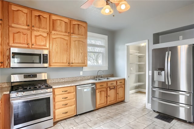 kitchen featuring appliances with stainless steel finishes, light tile patterned floors, ceiling fan, and sink