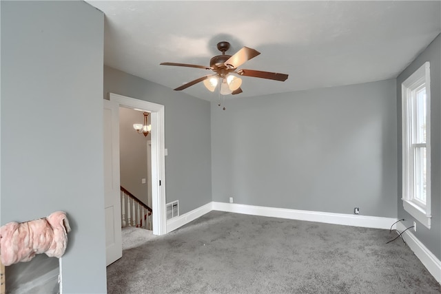 carpeted spare room featuring ceiling fan