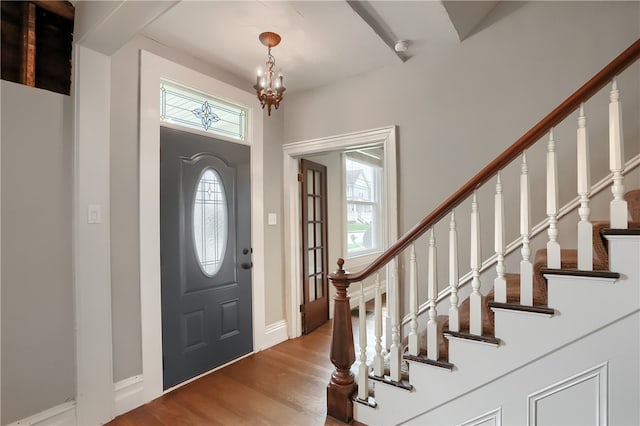 entrance foyer with wood-type flooring and a notable chandelier