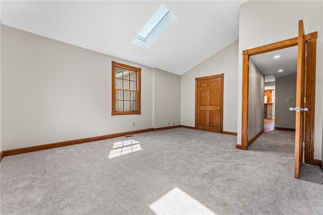 unfurnished bedroom with light colored carpet and vaulted ceiling with skylight