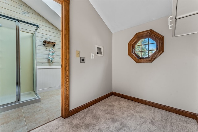 interior space featuring light colored carpet, wooden walls, and lofted ceiling