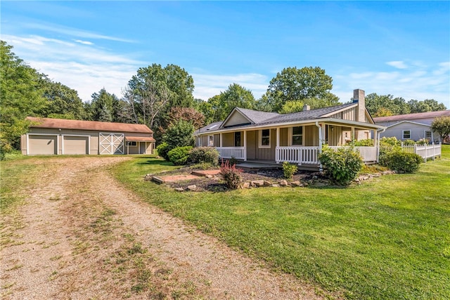 ranch-style home with a porch, a garage, a front yard, and an outdoor structure