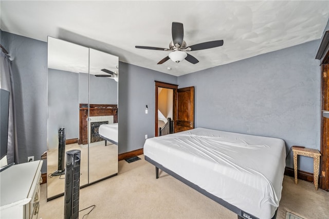 bedroom with a closet, ceiling fan, and light colored carpet