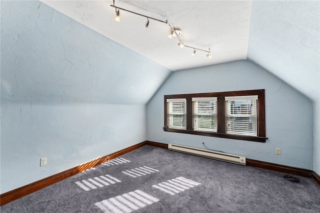 additional living space with vaulted ceiling, a baseboard heating unit, and carpet floors