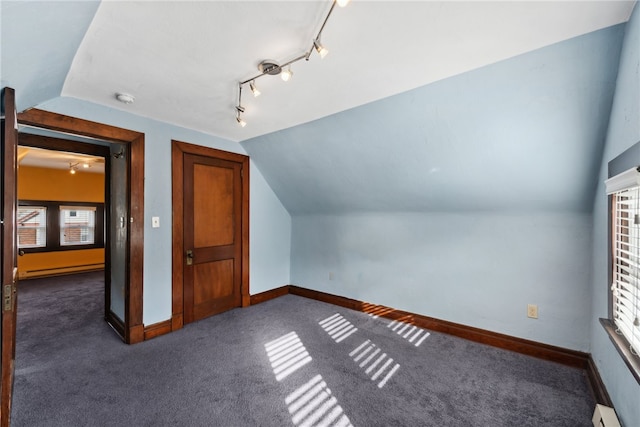 bonus room with baseboard heating, vaulted ceiling, and dark carpet