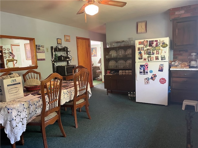 carpeted dining room with ceiling fan