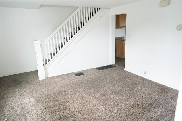 unfurnished living room with dark colored carpet